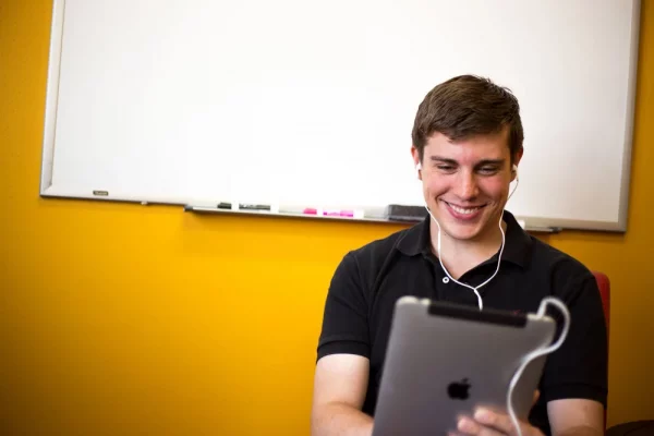 Young man with a tablet becoming proficient in a world language
