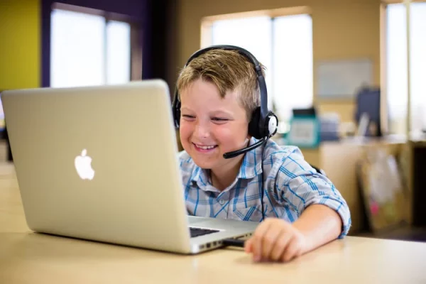 Young student taking an Avant adaptive world language proficiency test on a Apple laptop